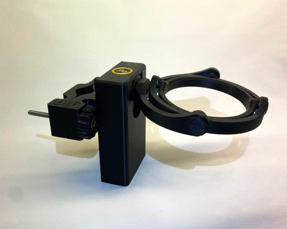 Das Bild zeigt den Cup n' Drive und den Cup n' Drive Outdoor. Der Cup n' Drive ist ein stabiler Getränkehalter, der für sicheren Transport sorgt. Der Cup n' Drive Outdoor ist eine stoßdämpfende Halterung, die als Zubehör für den Cup n' Drive dient. Zusammen ermöglichen sie einen stabilen Getränketransport, auch auf unebenem Gelände oder bei starken Bewegungen.