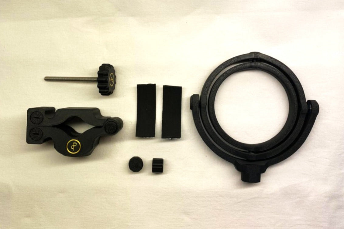 Das Bild zeigt den Lieferumfang des Cup n' Drive. Zu sehen sind der Getränkehalter, die Halterung mit Schraube, zwei selbstklebende Antirutschstreifen und zwei Abdeckkappen für die Schrauben. Alle Teile sind übersichtlich angeordnet.