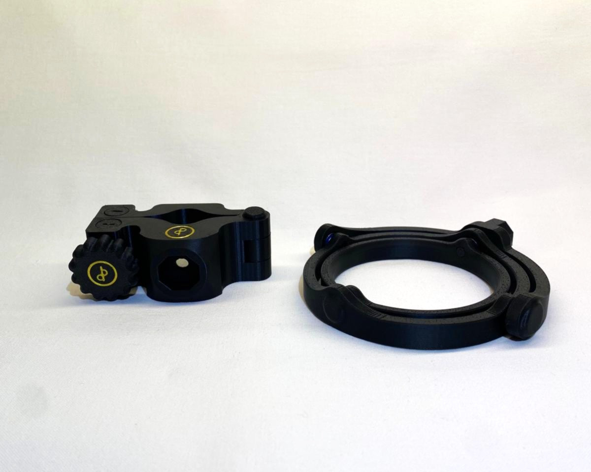 Der Cup n' Drive und die dazugehörige Halterung sind zu sehen. Der Getränkehalter ist rund und stabil, während die Halterung eine universelle Befestigungsmöglichkeit bietet. Die Konstruktion sorgt dafür, dass Getränke auch bei Bewegungen sicher bleiben.