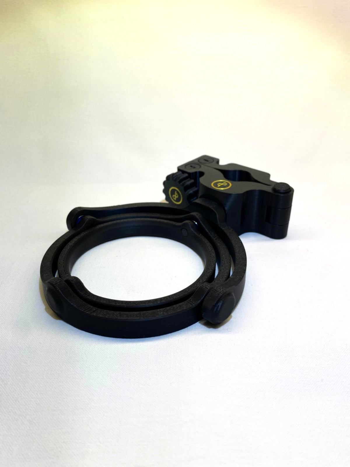 Der Cup n' Drive und die dazugehörige Halterung sind zu sehen. Der Getränkehalter ist rund und stabil, während die Halterung eine universelle Befestigungsmöglichkeit bietet. Die Konstruktion sorgt dafür, dass Getränke auch bei Bewegungen sicher bleiben.